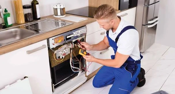 Technician diagnosing the controls of a built-in kitchen oven