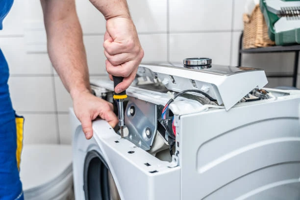 Close-up of a technician servicing internal washing machine components